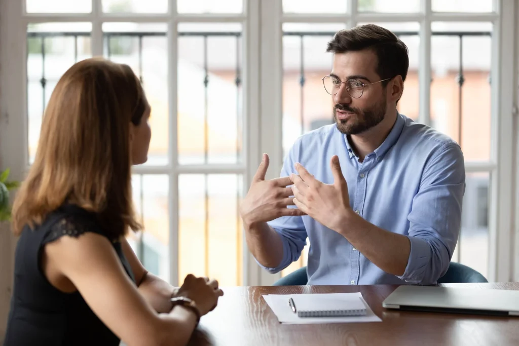 Man talking to his manager at office signs your coworker is threatened by you and how to deal with it